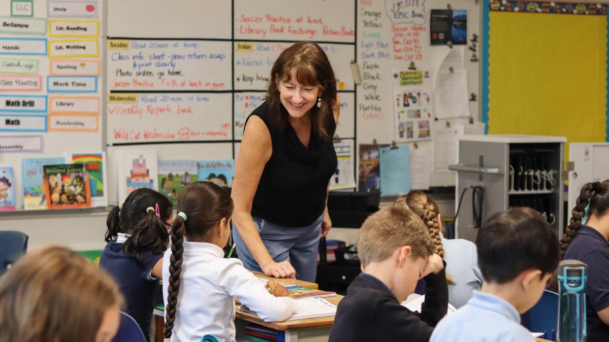 World Teachers Day 2024 Teacher smiling at her students who sit at their desks