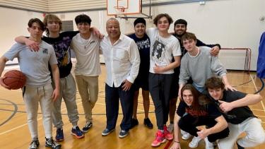 Kevin Group Photo -Basketball Group of students and Superintendent gather on basketball court after playing a game