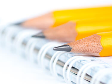 3 Pencil ends sitting on a notebook