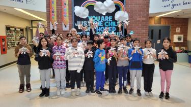 Blue Jay Bonhommes 2024 Group of elementary students standing in front foyer of school, showing of art project they completed