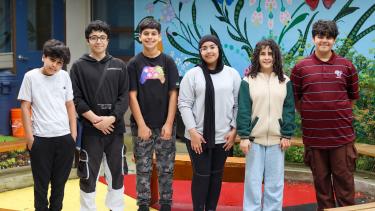SWANA club 2024 Six middle school students stand in a line, smiling at camera