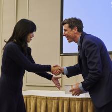 Board Vice Chair shakes hands with female employee who is receiving a gift box.