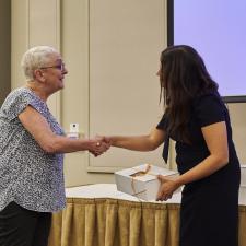 Trustee Kanda-Rajwan shakes hand with female employee receiving gift for long term service