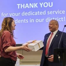 Dr. Kevin Godden smiling at female employee who received a gift for their long term service