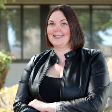 Stacey Hagkull, Human Rescources Woman with short brown hair wearing black leather jacket poses for photo