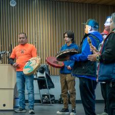 A small group of Indigenous Community members, students, elders drumming for the opening of the day