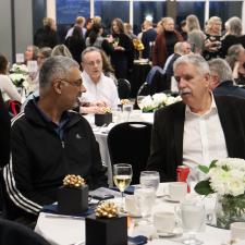 Two attendees sitting at table talking