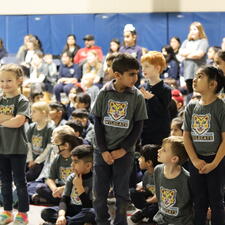 A few students standing up during an assembly to acknowledge their birthdays