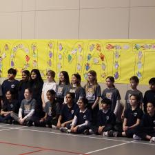 Group of students and their teacher stand in front of large sign that reads "You Matter"