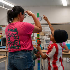 Teacher building blocks with a student