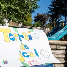 A student made poster sign that reads in French "Terrain de jeu!"