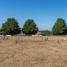 Elementary students playing games on their school field.